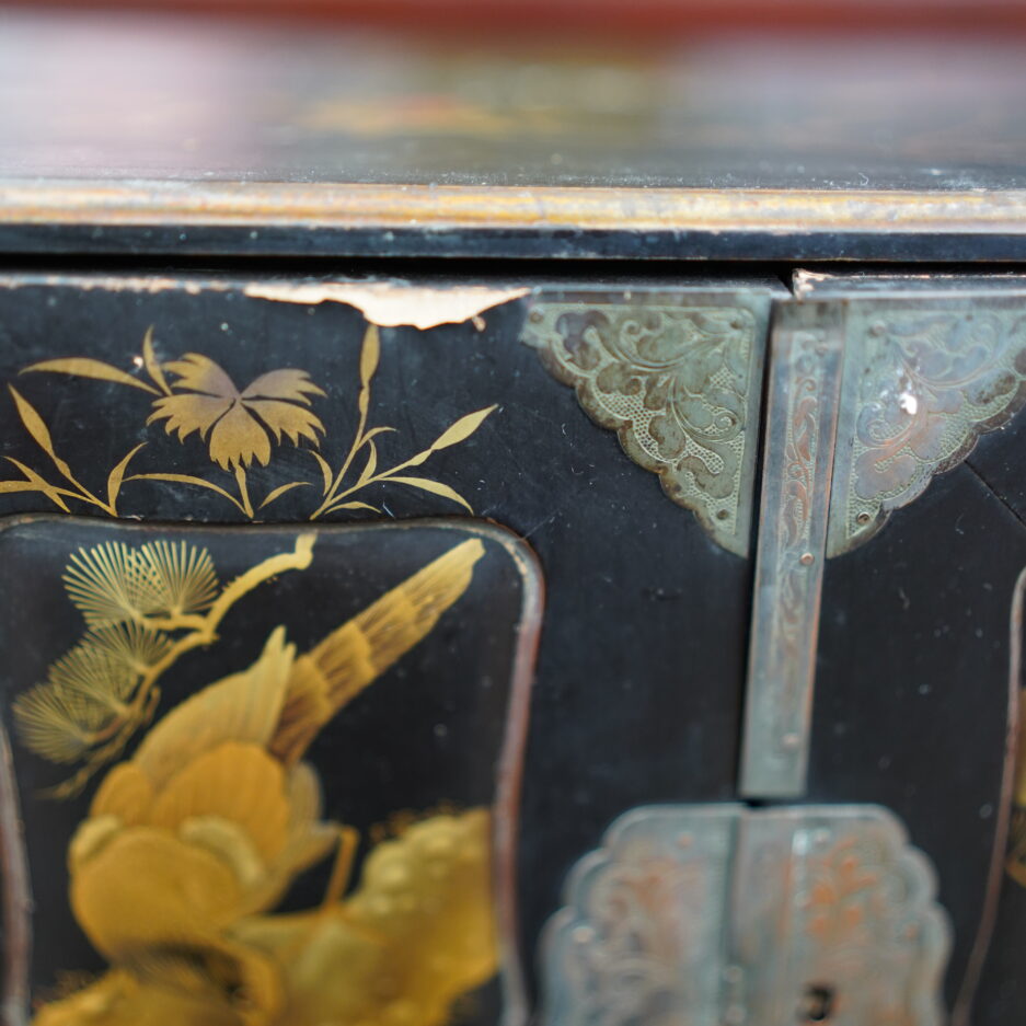 Cabinet en bois laqué noir à motifs de faucon et pins, branchages... en hira maki-e à huit tiroirs et deux portes.